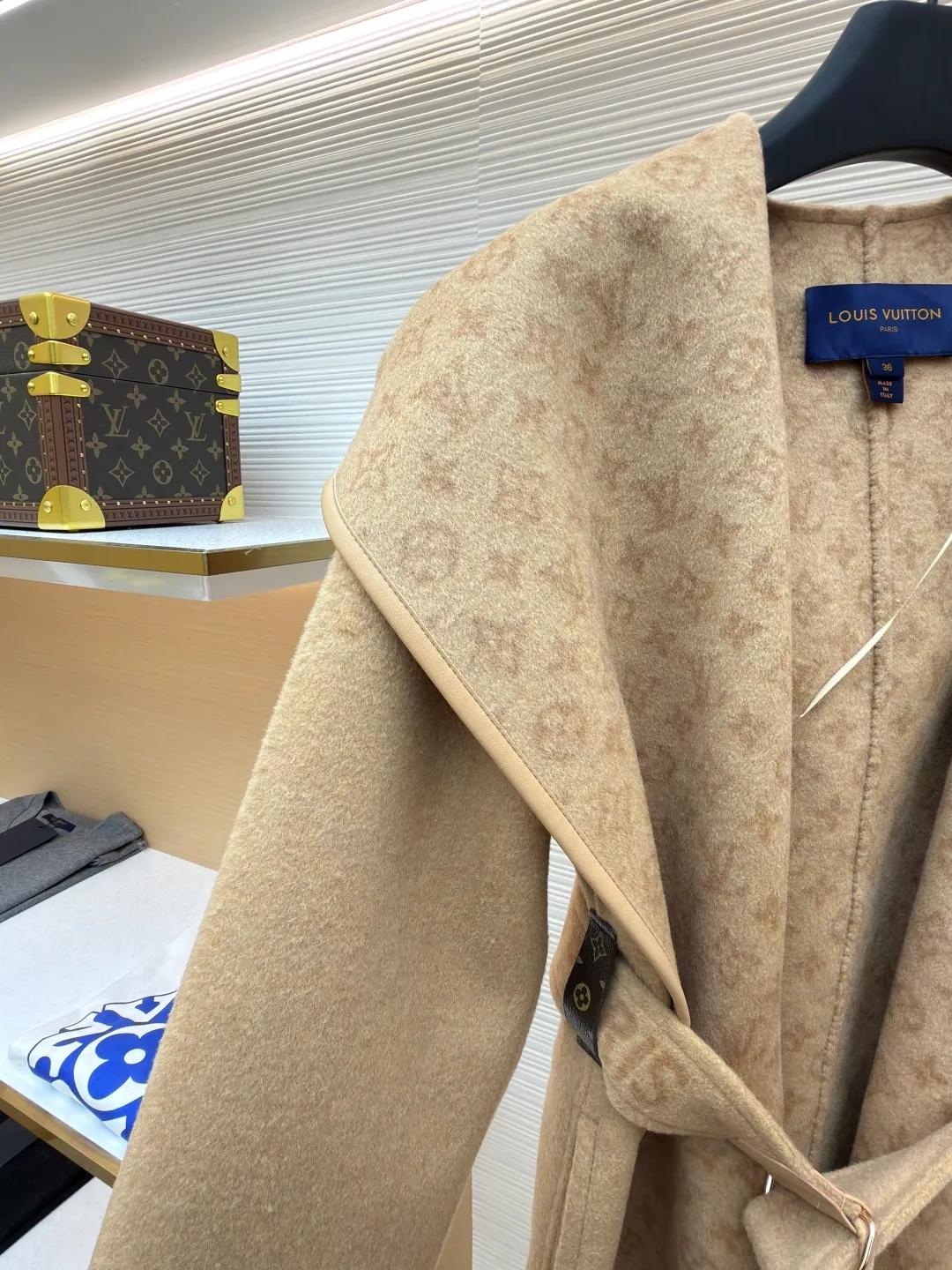 LOUIS VUITTON Wool lace-up wrap hooded coat (mid-length) ●Item number: 1682299-J025 ●Fabric: wool fabric ●Technology: jacquard production ●Color: khaki ●Version: loose fit ●Weight: about 1725 grams ●Size: 34-36-38-40 ●Description: This presbyopic wool coat is made of double-sided blended wool fabric imported from Italy. The main part is made of high-density matte black wool, which has been pre-shrunk and steam-set to ensure that the fabric is stiff and not easily deformed. The large lapel and belt areas use jacquard weaving technology to present the classic presbyopic pattern as a three-dimensional texture. The pattern is digitally positioned and plated to ensure that the texture is symmetrical and clear. The body of the garment is unlined and double-sided sewn to reduce the weight of the garment while improving skin-friendliness. The cuffs and hem are hand-stitched to reveal exquisite details. The waist is customized with a wide belt of the same fabric, with an adjustable buckle design with invisible stitching, allowing the silhouette to be freely adjusted; the neckline adopts a double-layer composite structure, combined with the fixation process of hand-made arch stitches, to make the large lapels more three-dimensional. Every splicing follows the precision sewing standard of 1cm/8 stitches, perfectly integrating craftsmanship and design aesthetics. The overall wiring is straight and delicate, the fabric is comfortable and soft, and the color is consistent without color difference. It can be matched with the same style to create a fashionable look and control various occasions. Customized accessories, complete with three standards, same style for men and women!